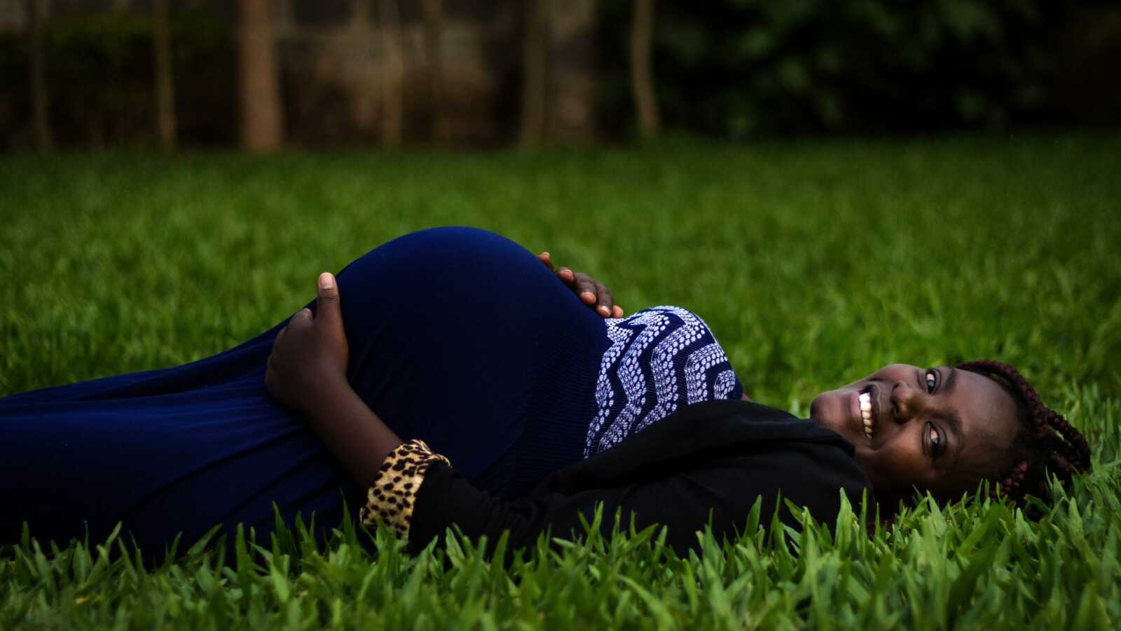 pregnant woman lying in grass