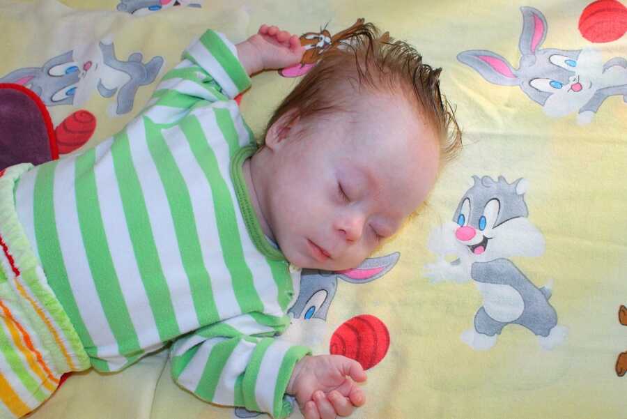 adopted son with Down syndrome sleeping in green striped shirt