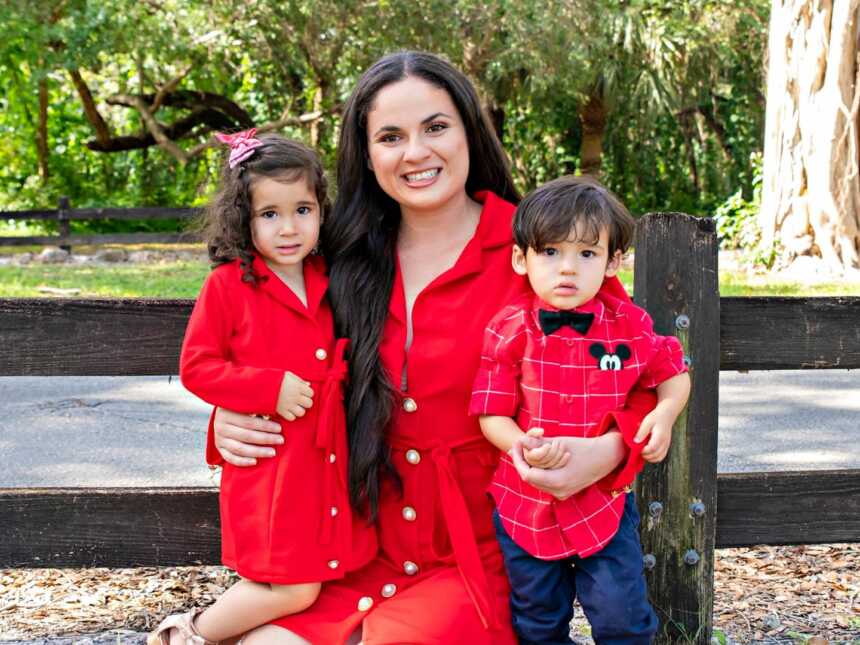 co-parenting mom poses with two children in red outfits