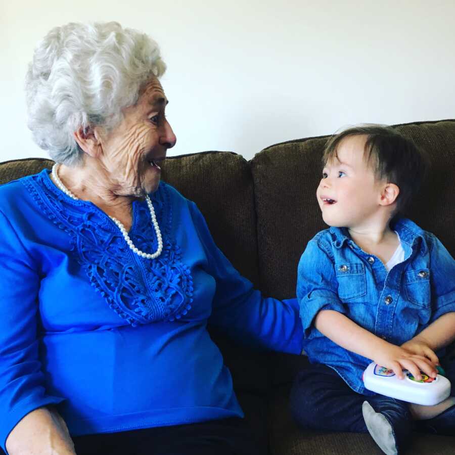 grandmother and adopted grandson with Down syndrome wearing matching blue tops