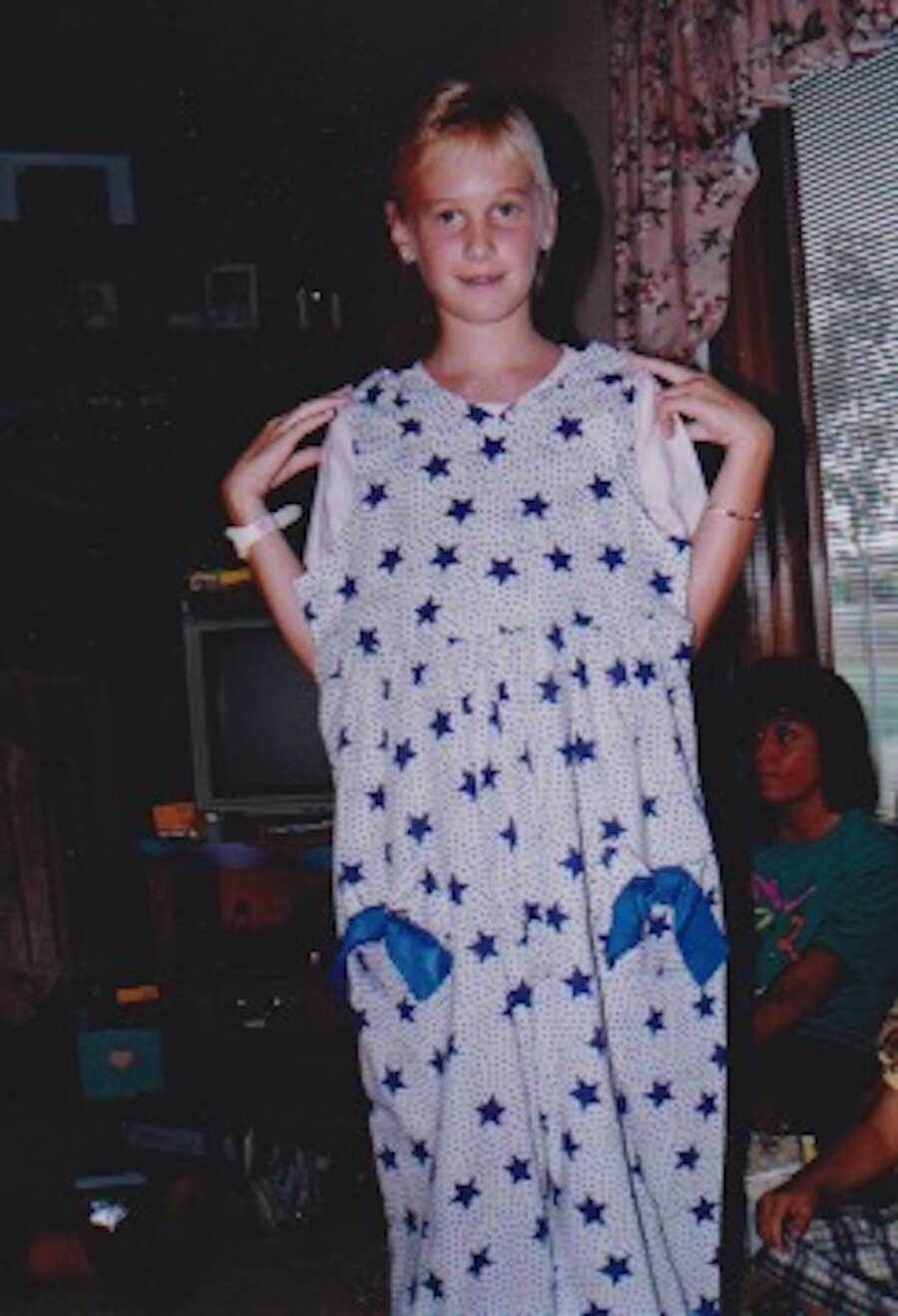 Throwback photo of teenage girl holding Christmas sweater sewn by her grandma up to her body