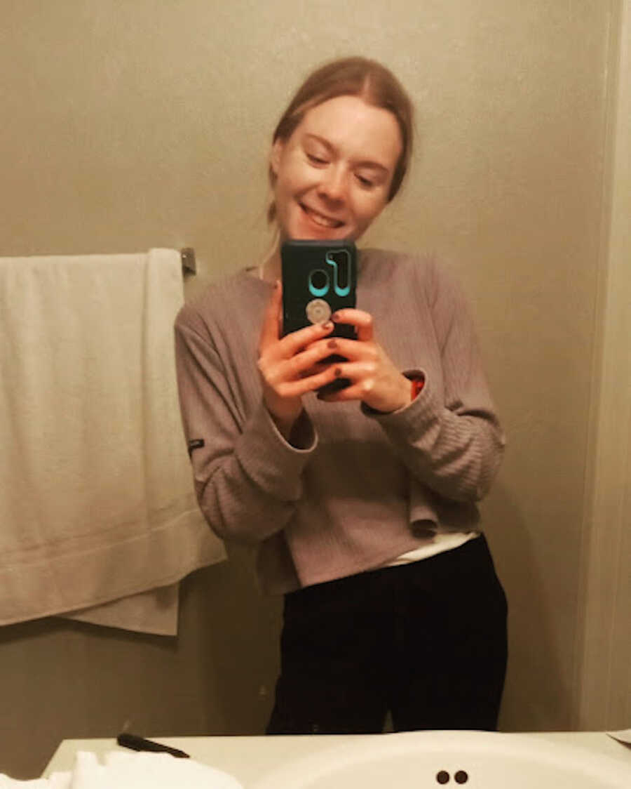 girl takes mirror selfie with phone while in active ED recovery