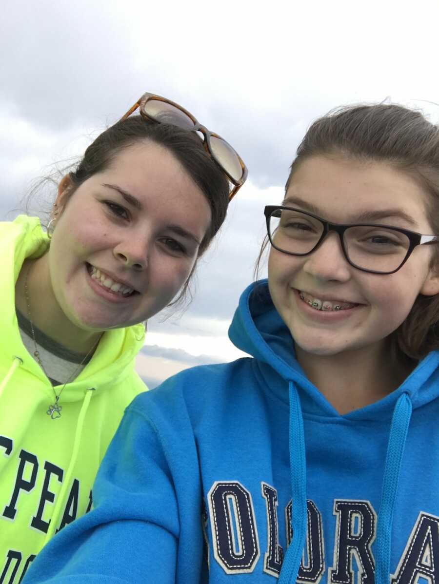 longtime friends take a selfie together smiling while wearing hoodies