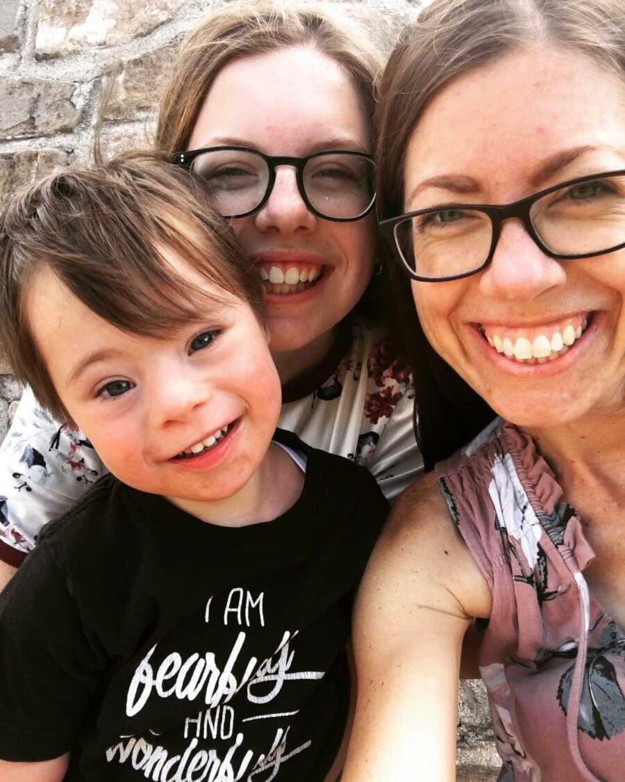 mom and sister with adopted son with Down syndrome