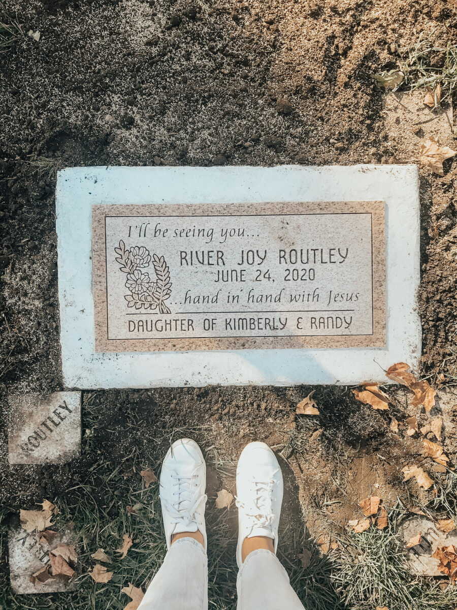 Mom standing over daughters grave with white shoes after having still birth pregnancy