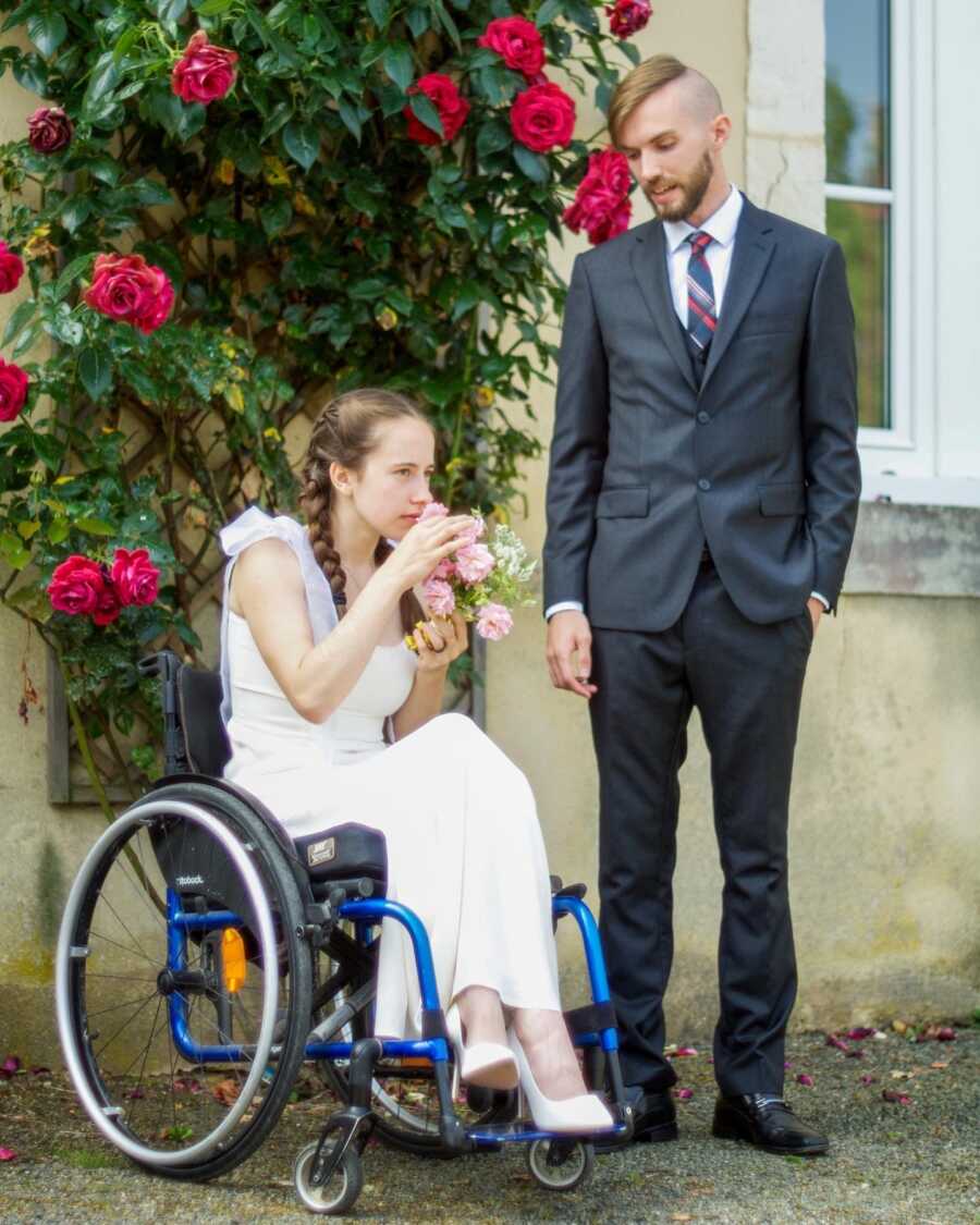 Paraplegic bride in wheelchair wearing wedding dress with groom 