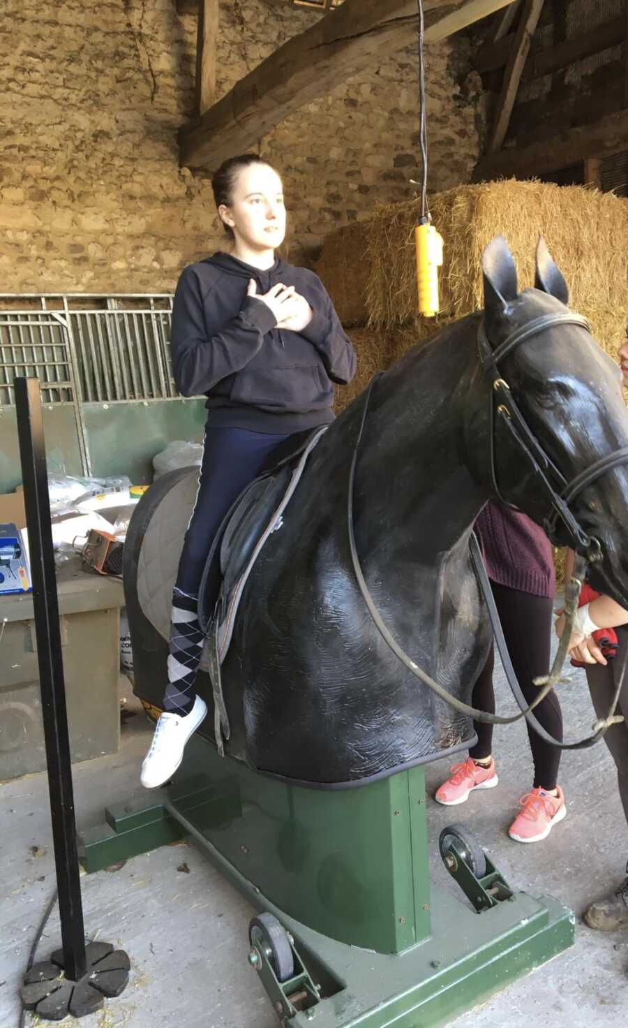 paraplegic woman practicing horseback riding on fake horse