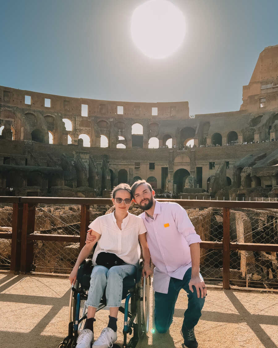 paraplegic woman with husband visiting Rome with colosseum in background