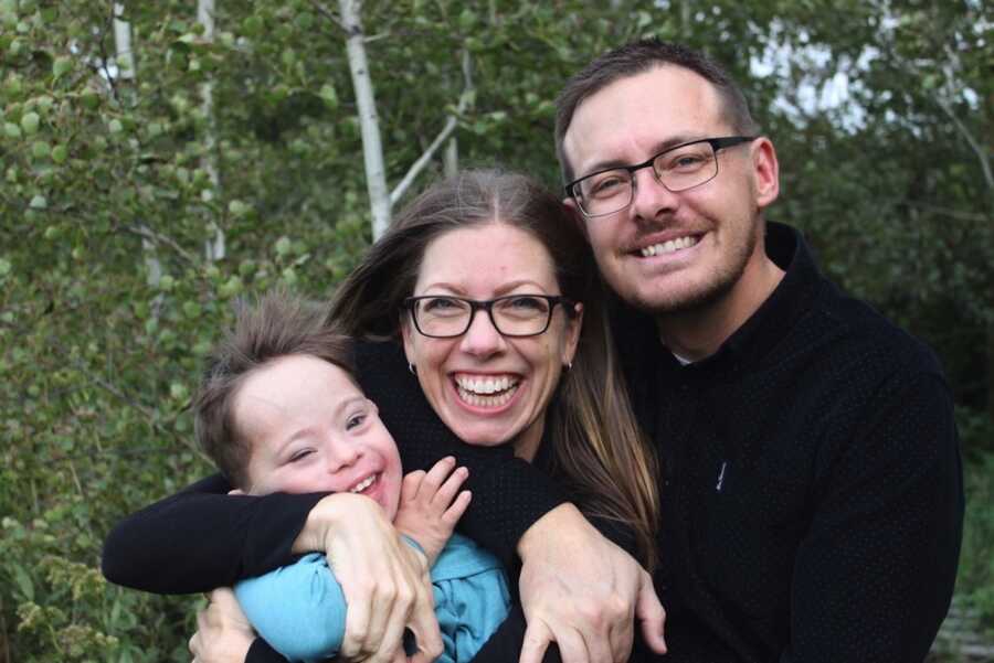 parents hugging son with down syndrome