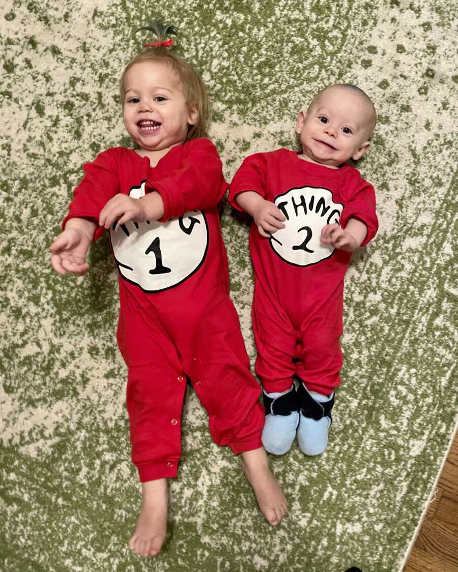 adopted brother and sister wearing matching red thing 1 and thing 2 onesies