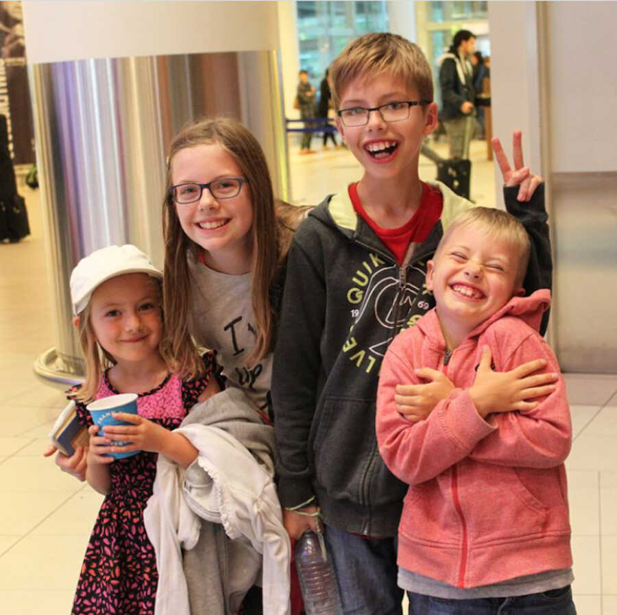 4 siblings at airport preparing to meet adopted brother with Down syndrome