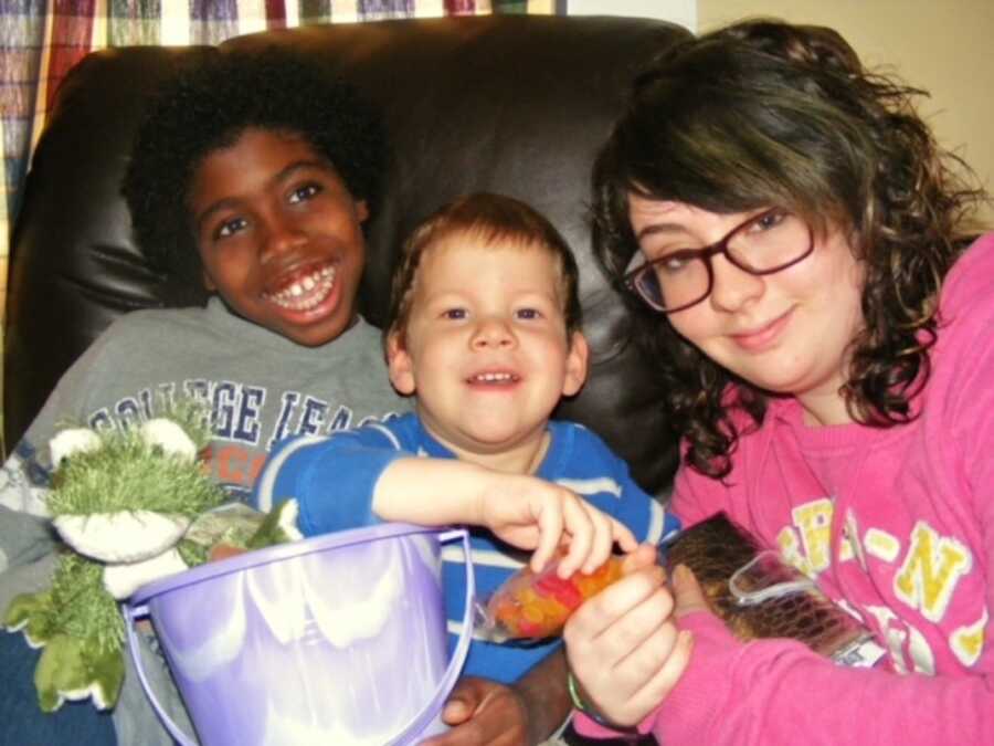 three siblings smile together on chair