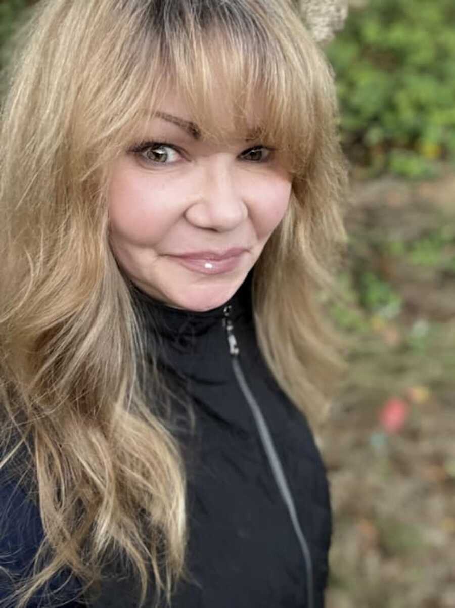 Mom with blonde hair and bangs wearing black jacket