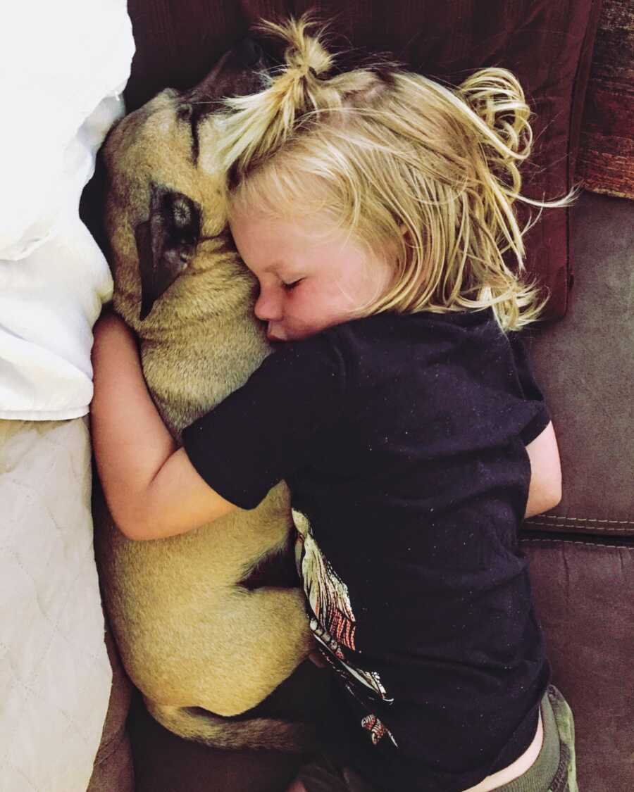 baby laying with puppy