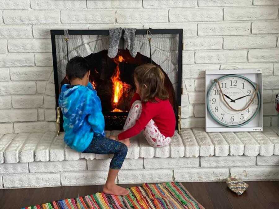 children sitting by the fireplace on ledge