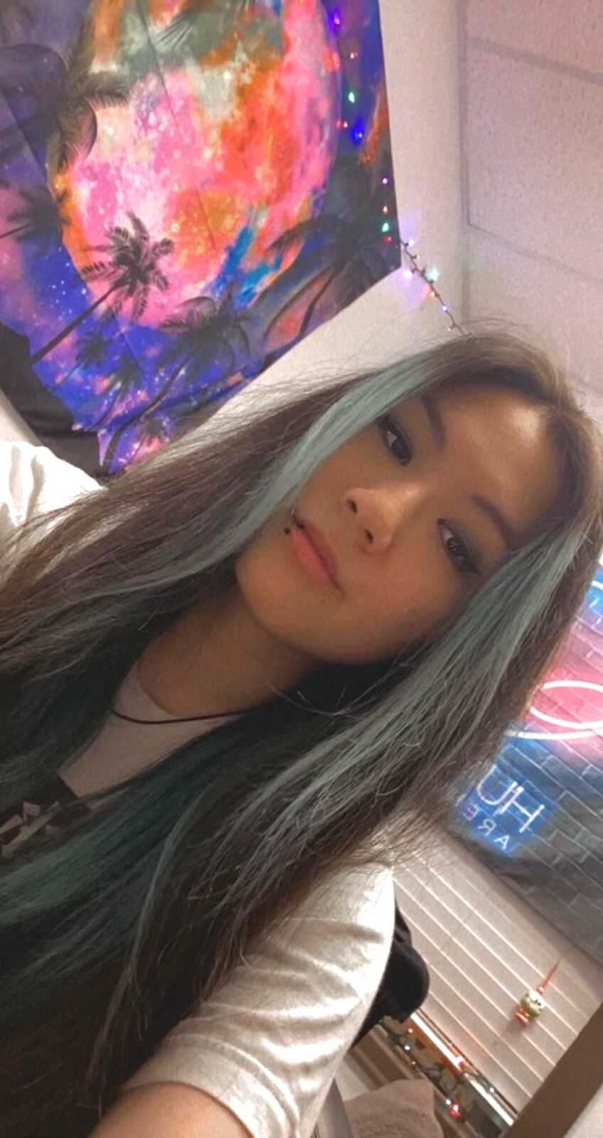 Chinese adoptee takes a selfie with blue streaks in hair