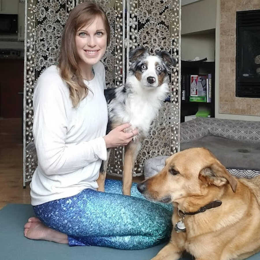chronic illness warrior sitting on floor with her two dogs