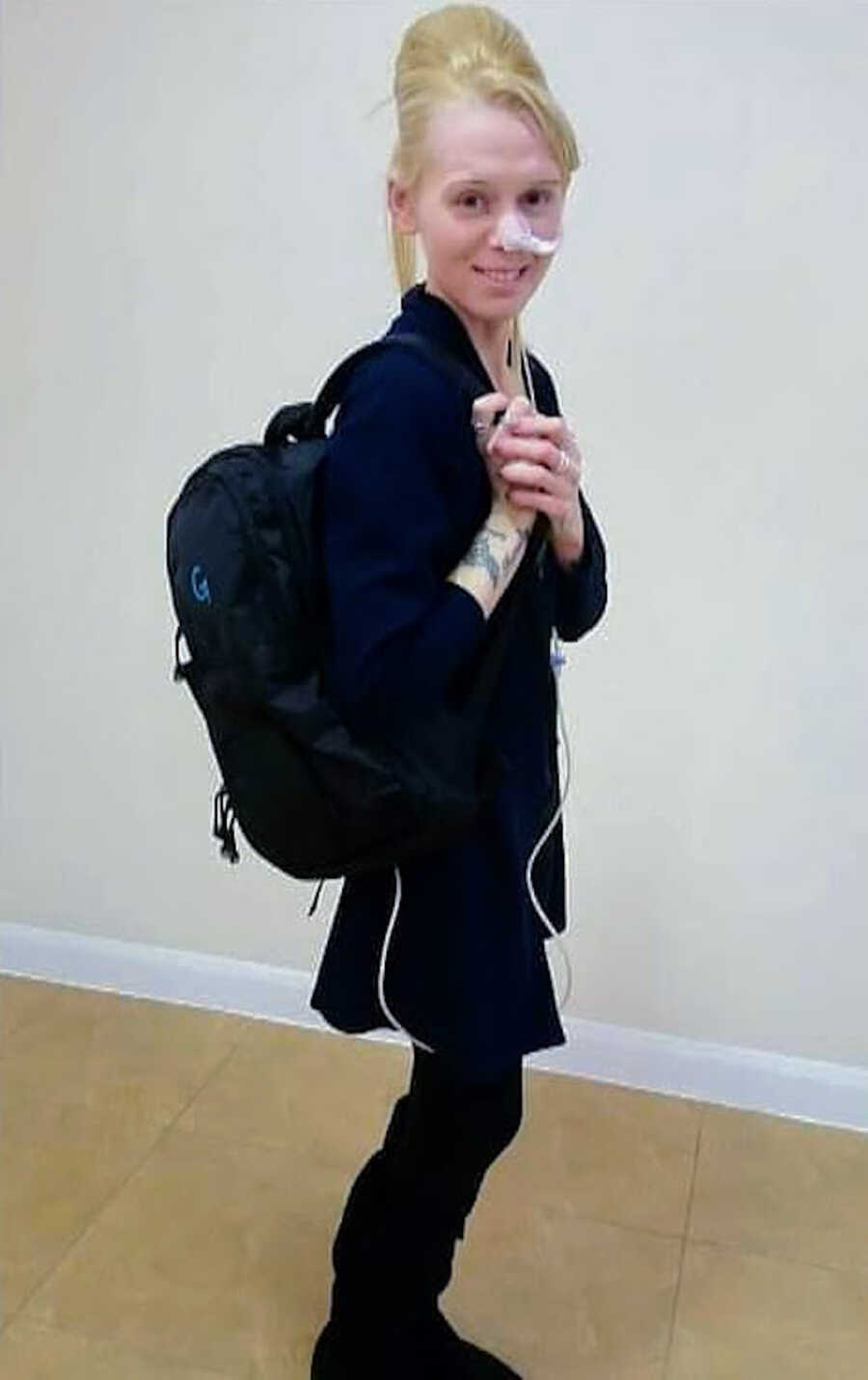 woman with chronic illness has feeding tube and backpack on
