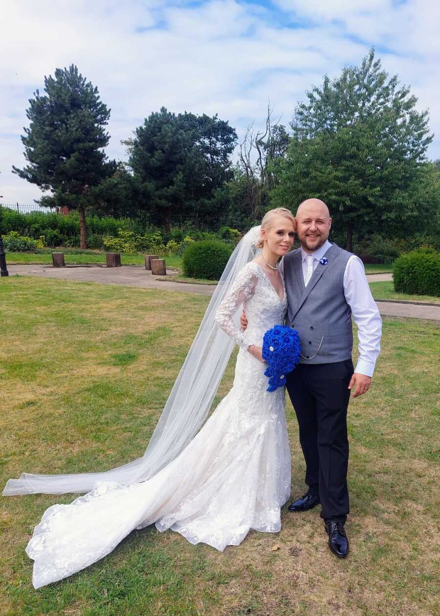 couple on their wedding day stand outside 