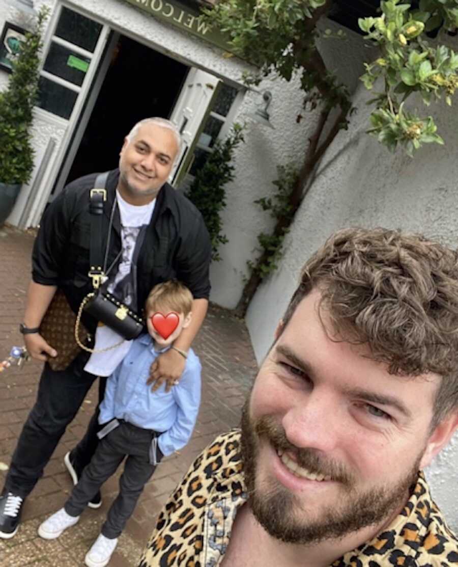 gay couple takes selfie with their adoptive son