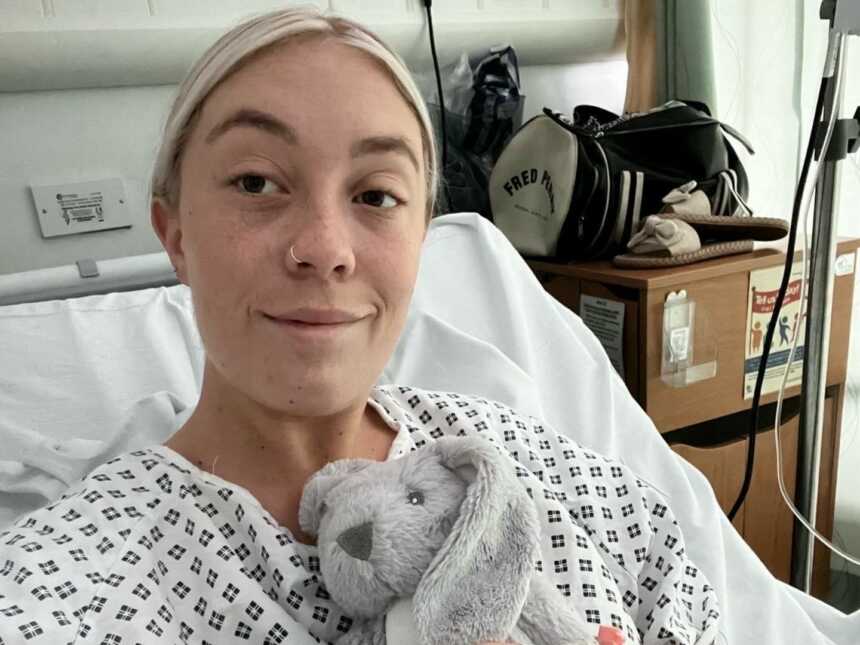 endometriosis warrior sitting in hospital bed while holding a bunny stuffed animal