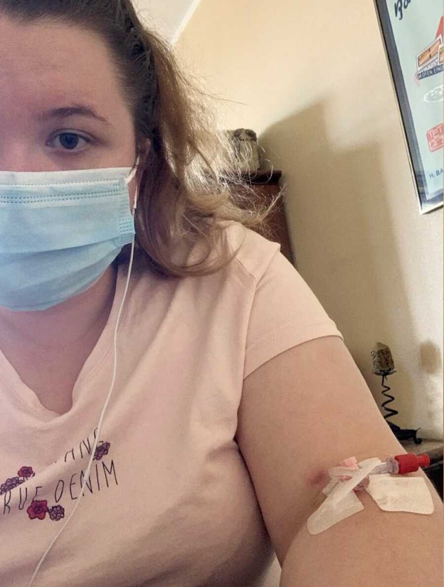 epileptic woman wearing a face-mask with an IV inserted into her arm