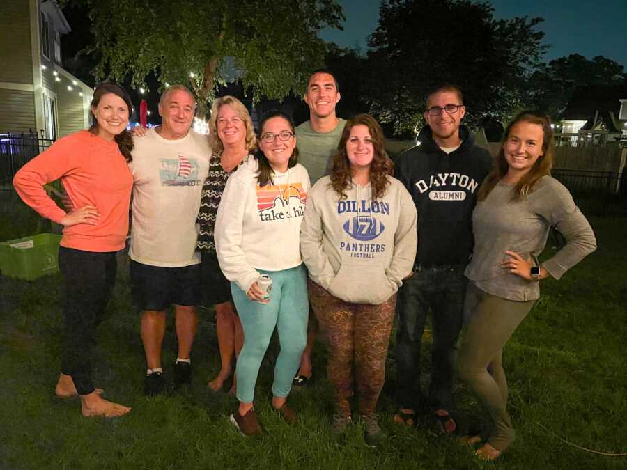 large group of family gathered outside while it is dark out