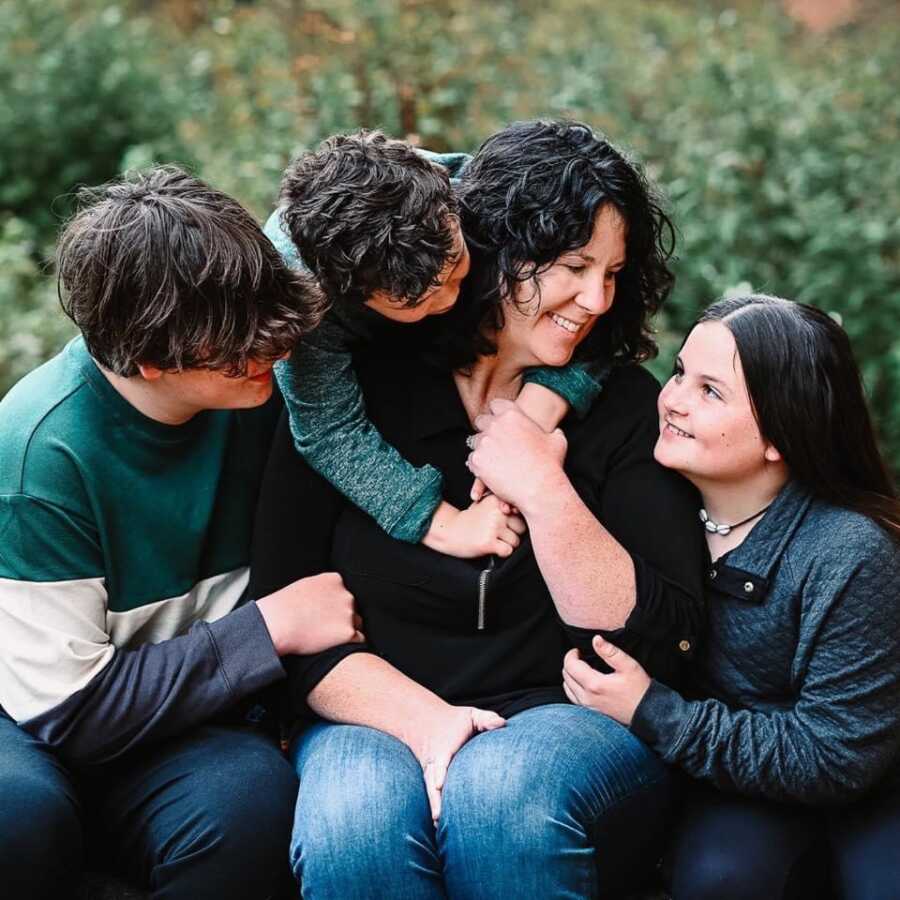 family of 4 wearing matching green color for group family photo