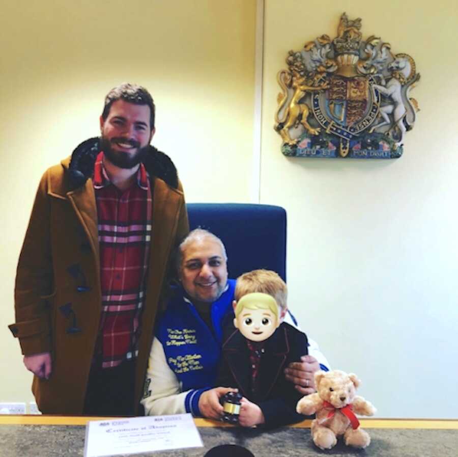 gay couple with their adoptive son on his adoption day