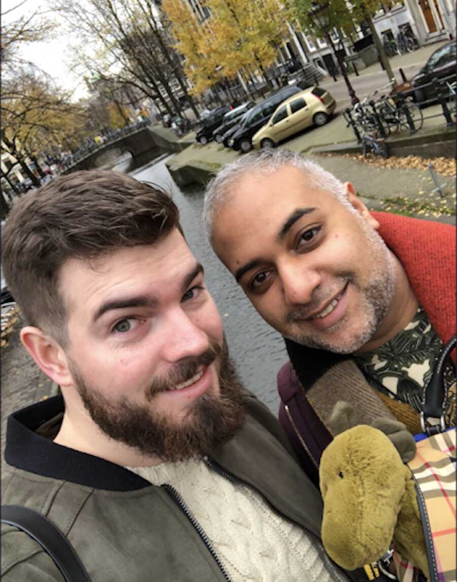 gay couple holds stuffed animal bought for their adoptive son