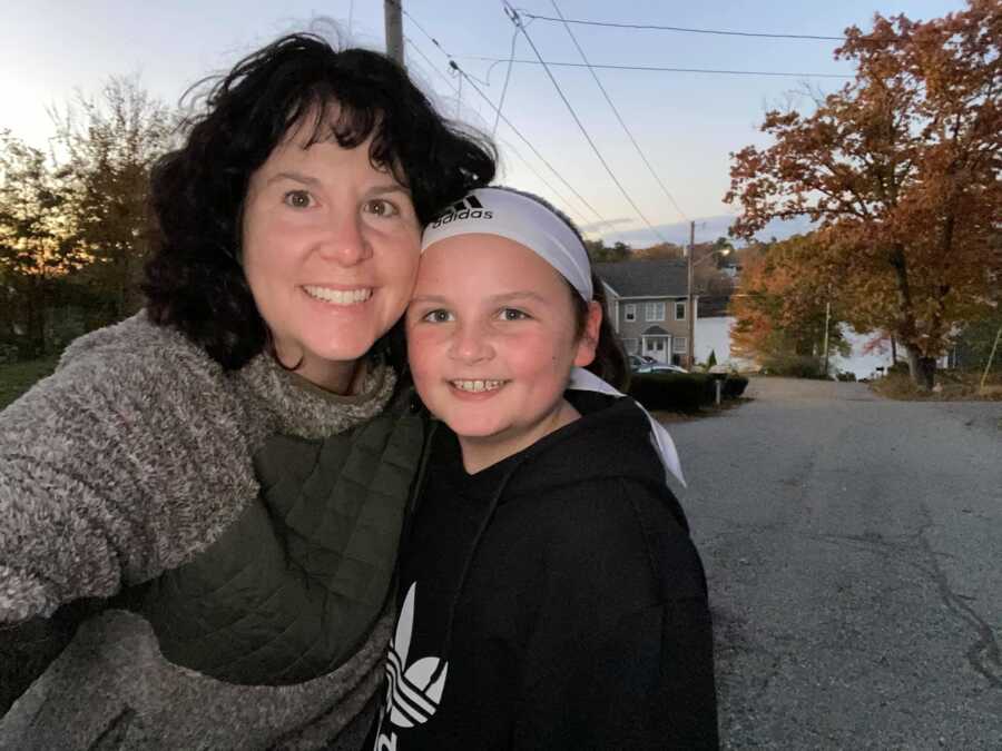 mom with curly black hair with area over daughter wearing white headband 