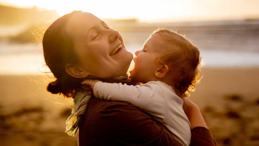 mom holding baby at beach