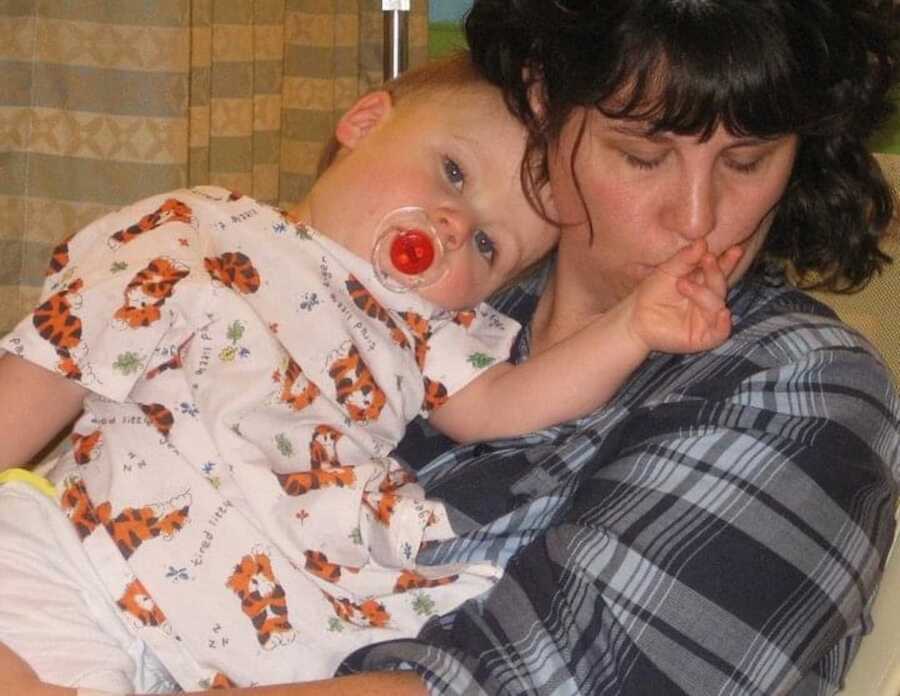mom with curly black hair lying on couch with baby son resting on her chest