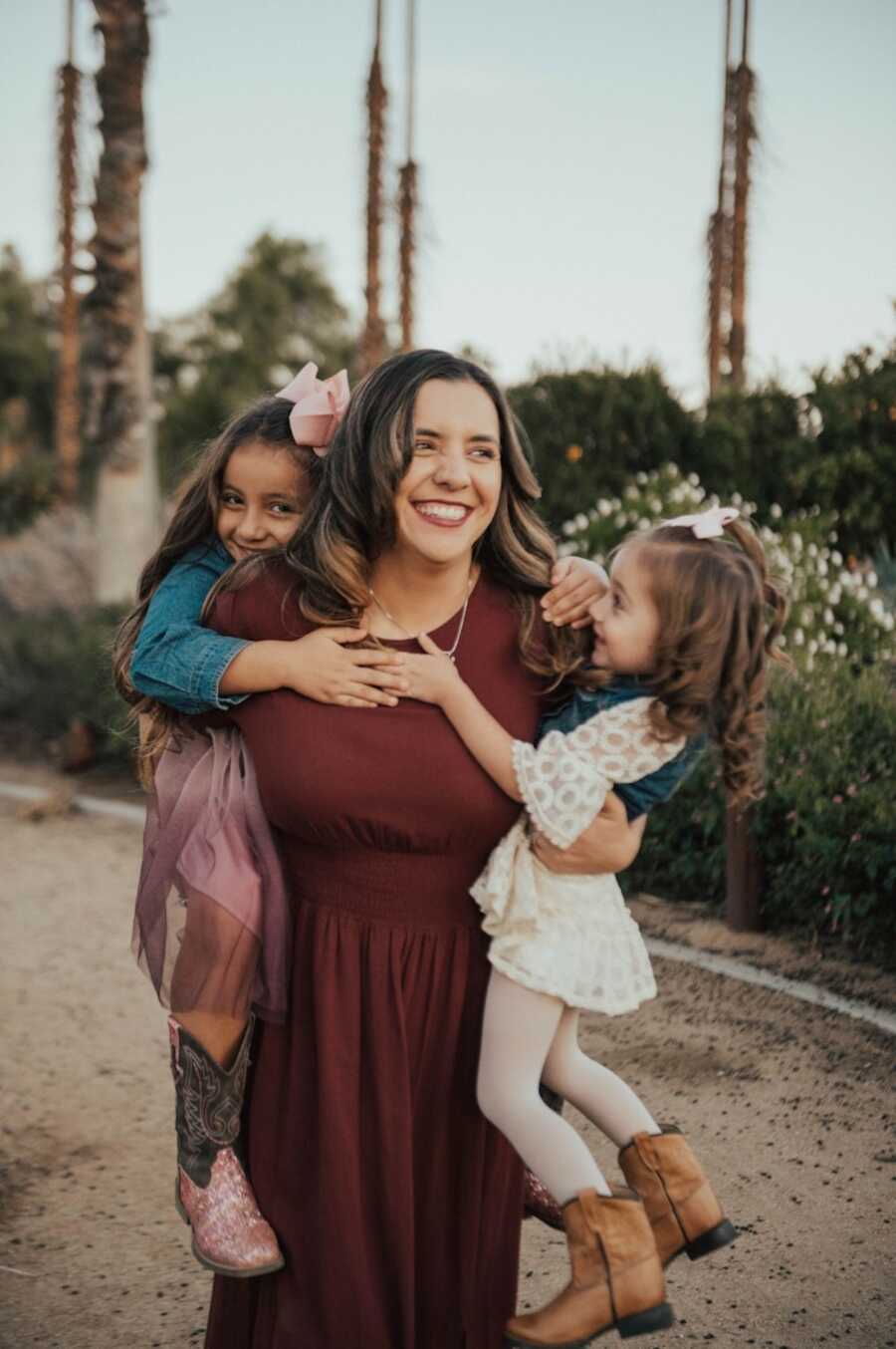 childhood sexual abuse survivor holds her two daughters laughing