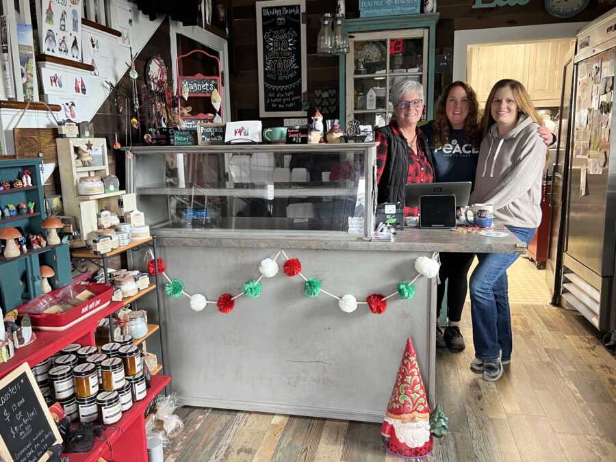 Small business owners standing behind checkout counter of knick knack shop