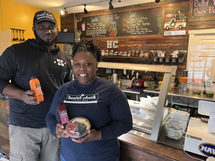 black small business owners holding juices from their acai bowl business