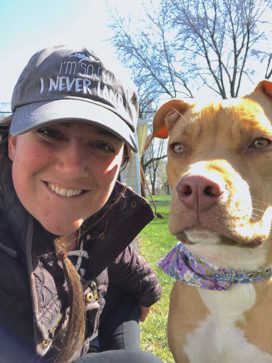 woman takes a selfie in a hat with her dog