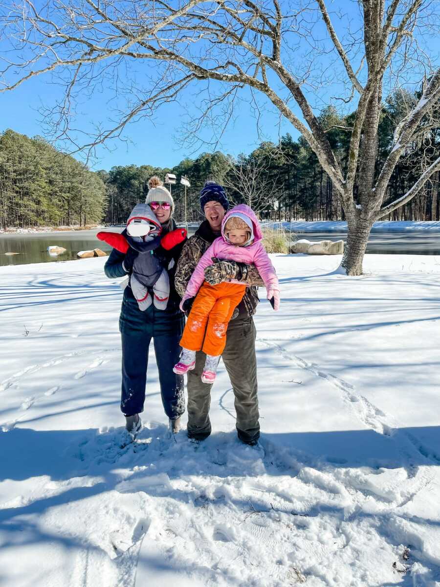 Family poses in their snowsuits 