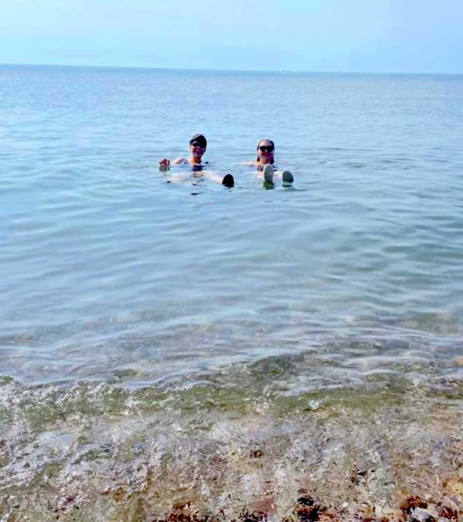 mom and daughter floating while in the dead sea together