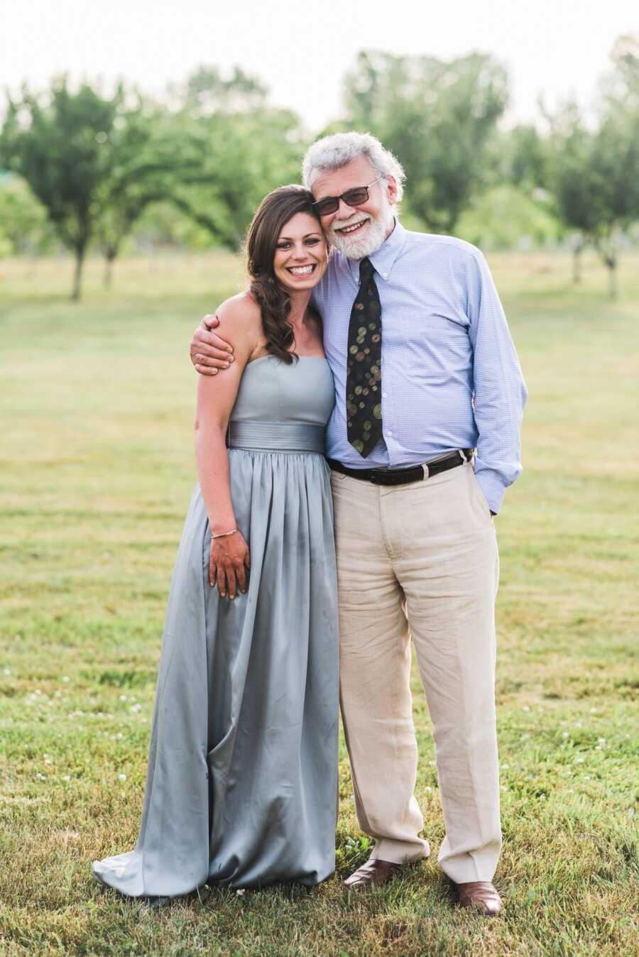 Woman smiling in light blue dress alongside father