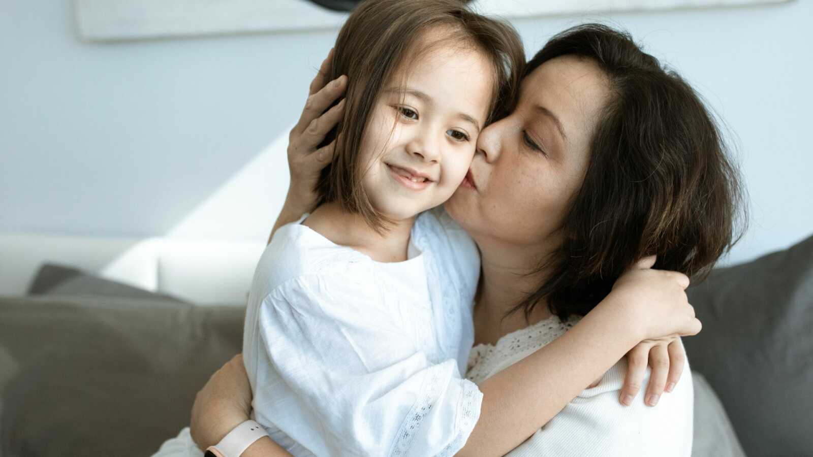 mother kissing daughter on cheek