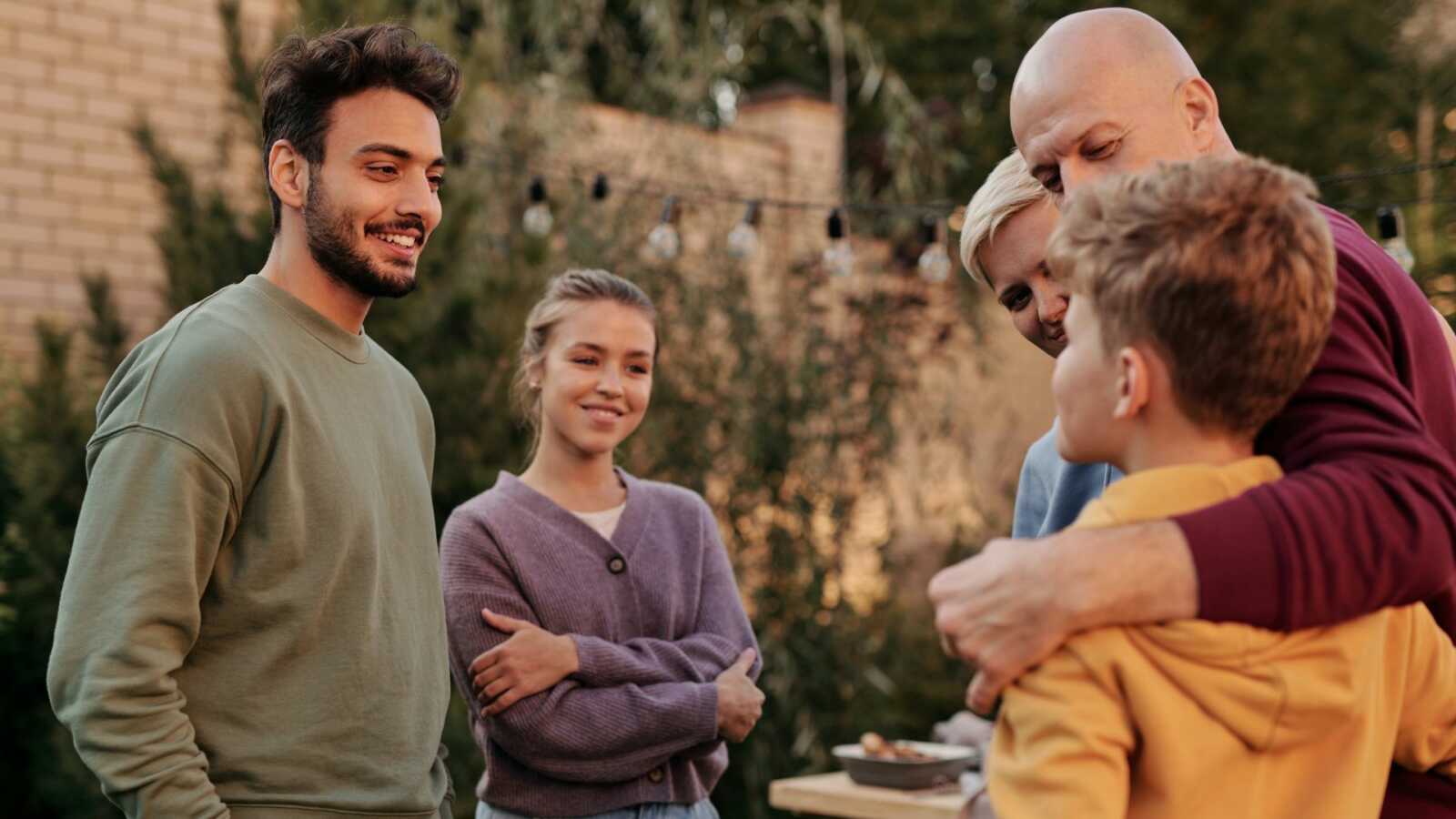 Two people meet a young boy with his parents