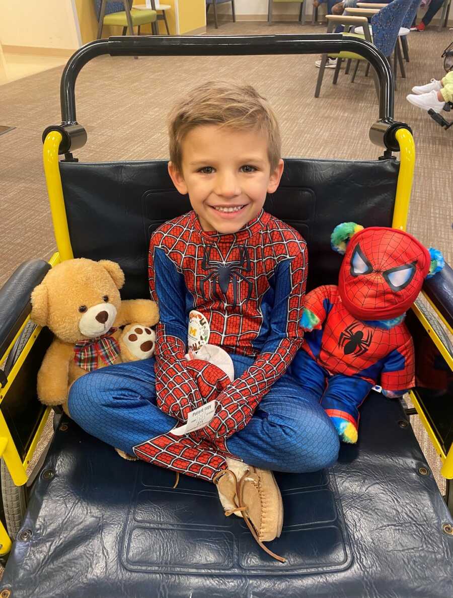 Boy in Spider Man costume sits in wheelchair 